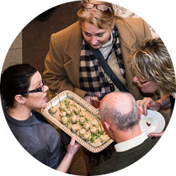 A server delivering appetizers as part of a full service catered event